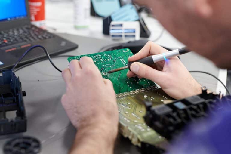 Un employé de Cotrolia réalise une soudure sur un circuit imprimé