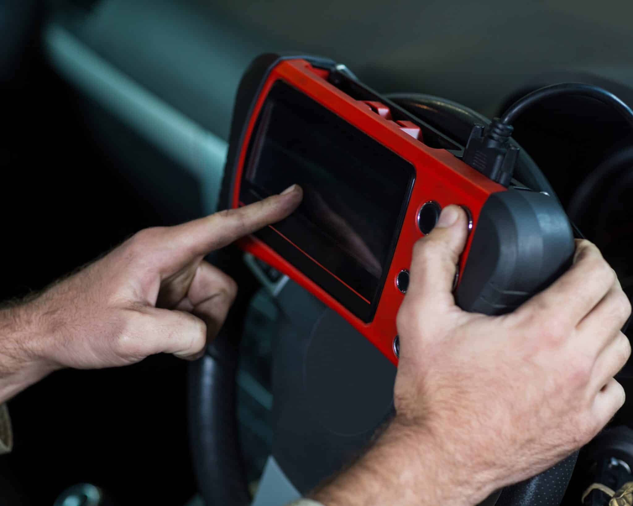 Mechanic using a diagnostic tool at the repair shop